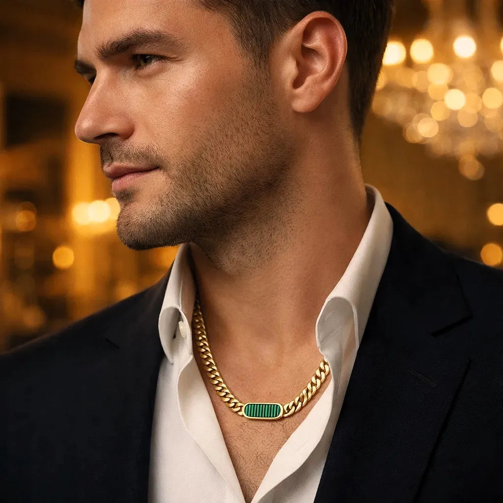 Gold Cuban link chain necklace with emerald green onyx oval tag centerpiece, worn on man's neck, high-polish 18K gold finish, luxury close-up portrait in warm ambient lighting